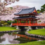 Um jardim japonês tradicional com um lago sereno e uma ponte vermelha, cercado por árvores de cerejeira em plena floração.