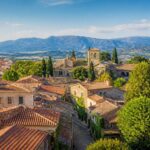 Vista panorâmica de cidades pequenas próximas a Madrid com casas tradicionais, ruas de pedra e vegetação ao redor.