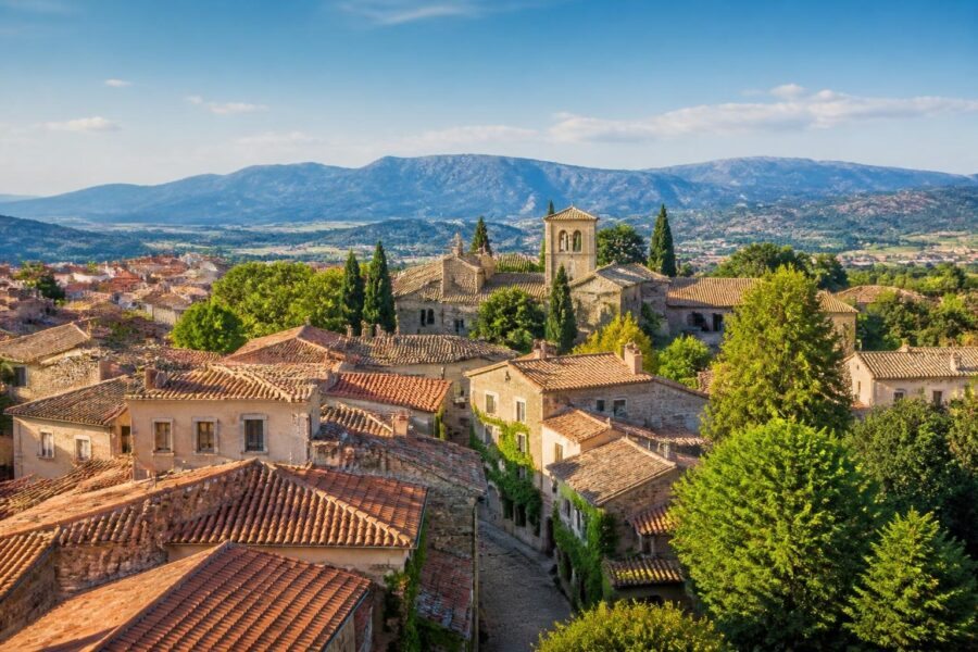 Vista panorâmica de cidades pequenas próximas a Madrid com casas tradicionais, ruas de pedra e vegetação ao redor.